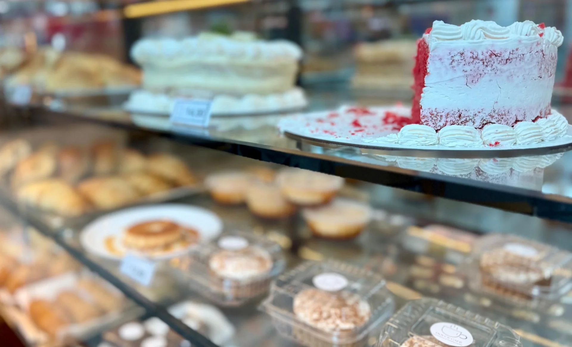 Bolo red velvet com cobertura branca em bancada de vidro
